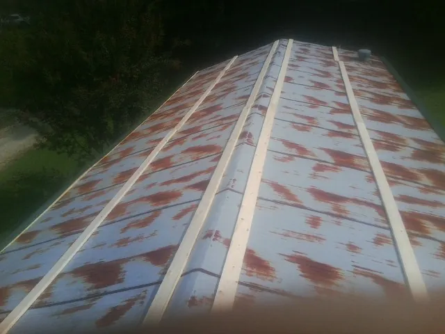 Rusted metal roof panels with new wood purlins before replacement — Storm Damage Roof Repair in Lind by Roofing Brothers