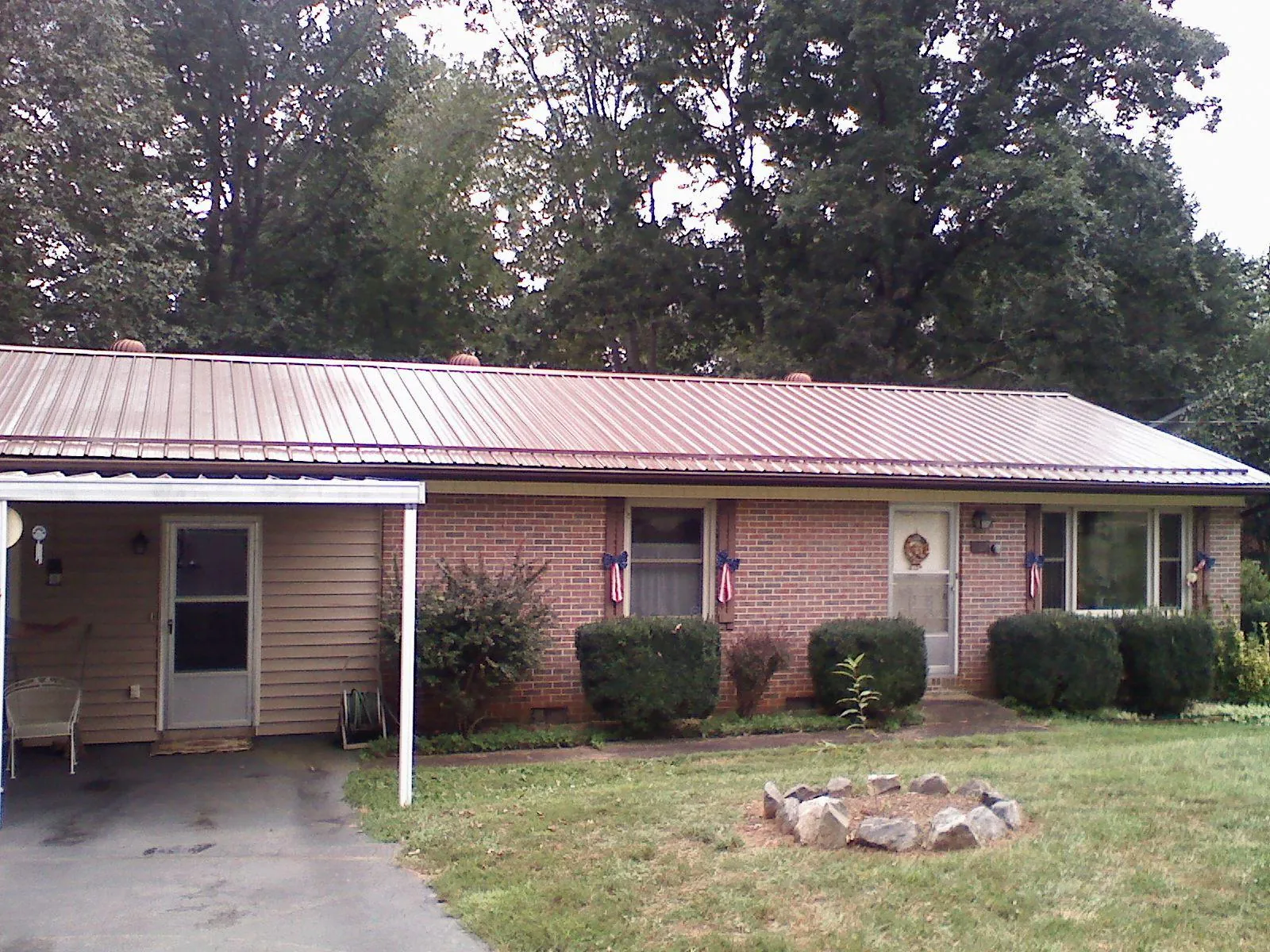 Bronze metal roof and carport on a brick ranch home — Roof Repair work by our crew in Lind