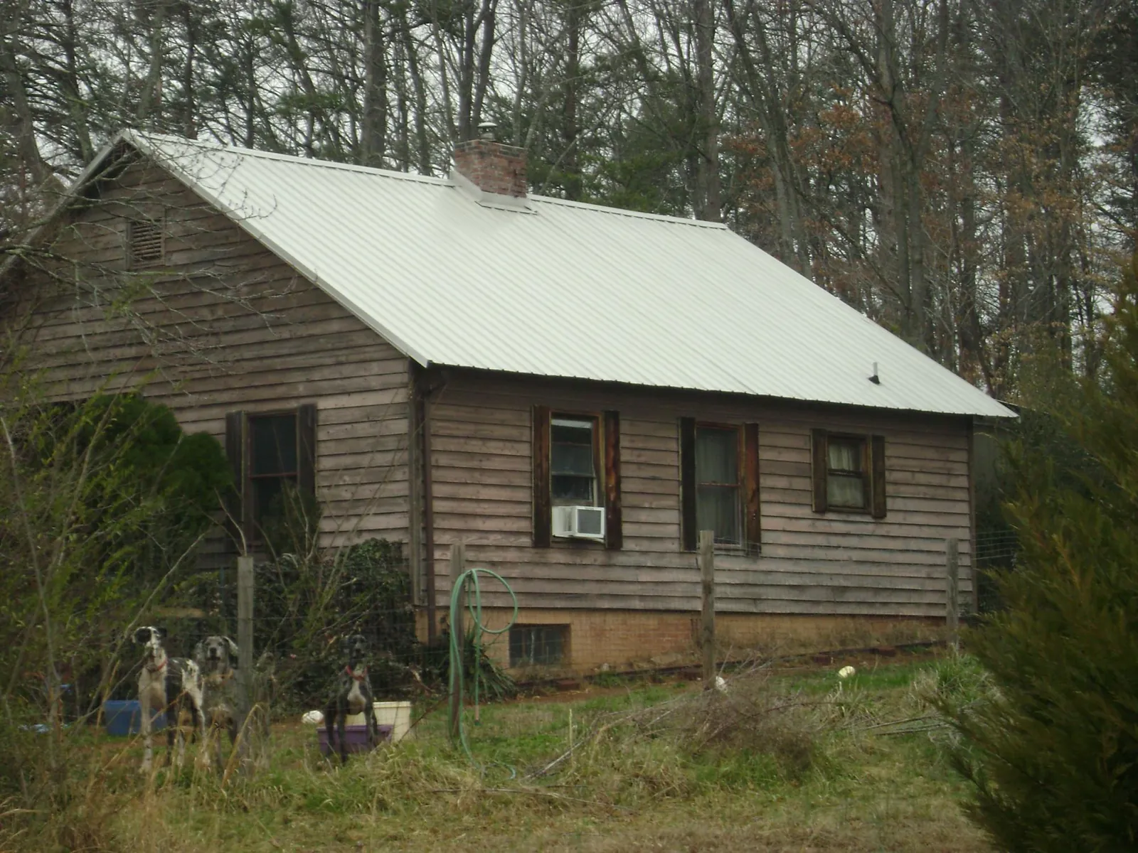 White metal roof on an old wood sided farmhouse, from a Metal Roof Installation job in Lind